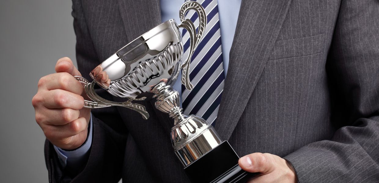 (© Brian A Jackson / shutterstock) Hände halten einen Pokal